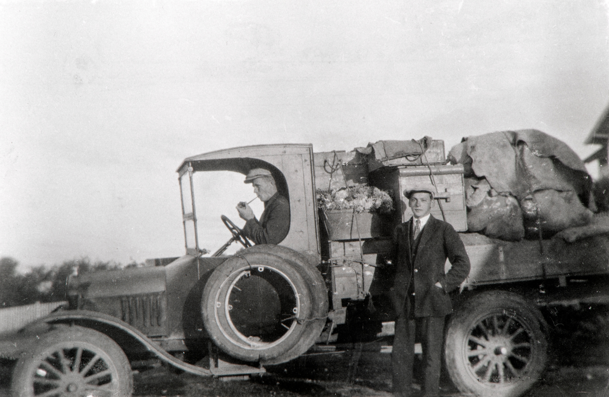 Lastebil med torglass på Bjørnstad, Nes, Hedmark. Sannsynligvis en Ford TT. Sjåfør er Erik Dørfel og Anton Leiknes står ved siden av. Bjørnstad, Nes, Hedmark.