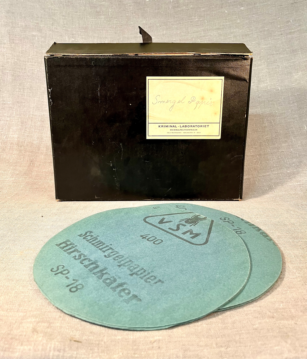 Sort boks i papp med runde pussepapir.