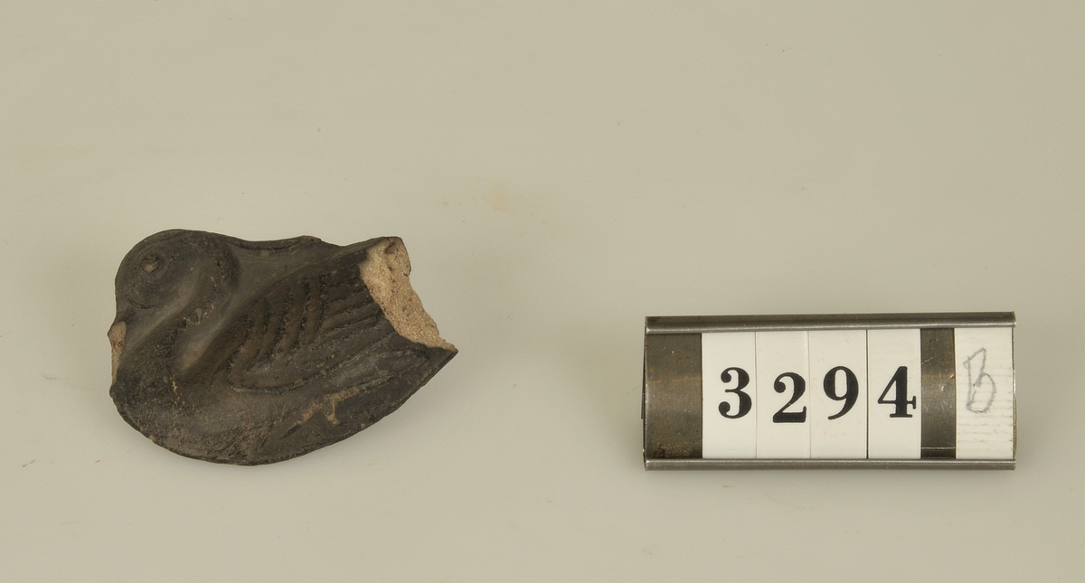 Högrelief med fågelmotiv.
Av lera som pressats i formar och sedan bränts.
Den större av relieferna har på baksidan tydligt
hudavtryck av en fot.

a) Storlek: 8,5 x 6 cm.
b)     "        5 x 3,5 cm.

Har tillhört de Adelsköldska samlingarna.
