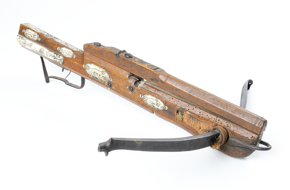 Armborst tillverkat i valnötsträ med båge av stål, försedd med inbygt lås med snälltryck. Stocken har inläggningar av elfenben i medaljonger, vari djur är ingraverade. På kindsidans plattor syns vildsvin, björn, löpande hund och vilande lejon, och på yttersidan löpande hundar, lo och springande hare och lejon. På kolvens översida finns två rankornerade plattor och tumgrepp med skraffering. Bakplåten i elfenben har en inristad krans. Skenan över pilrännan är fastskruvad vid stocken med två järnskruvar. På denna skena finns också sikte och korn av järn. Bågen i stål är i rektangulär genomskärning och hålls fast i kolven med en båglindning. Framför bågen finns en liten bygel i järn, och även varbygeln undertill är i järn. För att spänna bågen så krävs en hävstång eller vindspel för att göra detta. Armborstet har åtta pilar. (Inv. nr. L 3 - L 10), samt spännanordning.
Inskrivet i huvudkatalogen 1794.