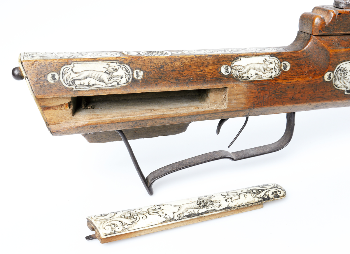 Armborst tillverkat i valnötsträ med båge av stål, försedd med inbygt lås med snälltryck. Stocken har inläggningar av elfenben i medaljonger, vari djur är ingraverade. På kindsidans plattor syns vildsvin, björn, löpande hund och vilande lejon, och på yttersidan löpande hundar, lo och springande hare och lejon. På kolvens översida finns två rankornerade plattor och tumgrepp med skraffering. Bakplåten i elfenben har en inristad krans. Skenan över pilrännan är fastskruvad vid stocken med två järnskruvar. På denna skena finns också sikte och korn av järn. Bågen i stål är i rektangulär genomskärning och hålls fast i kolven med en båglindning. Framför bågen finns en liten bygel i järn, och även varbygeln undertill är i järn. För att spänna bågen så krävs en hävstång eller vindspel för att göra detta. Armborstet har åtta pilar. (Inv. nr. L 3 - L 10), samt spännanordning.
Inskrivet i huvudkatalogen 1794.