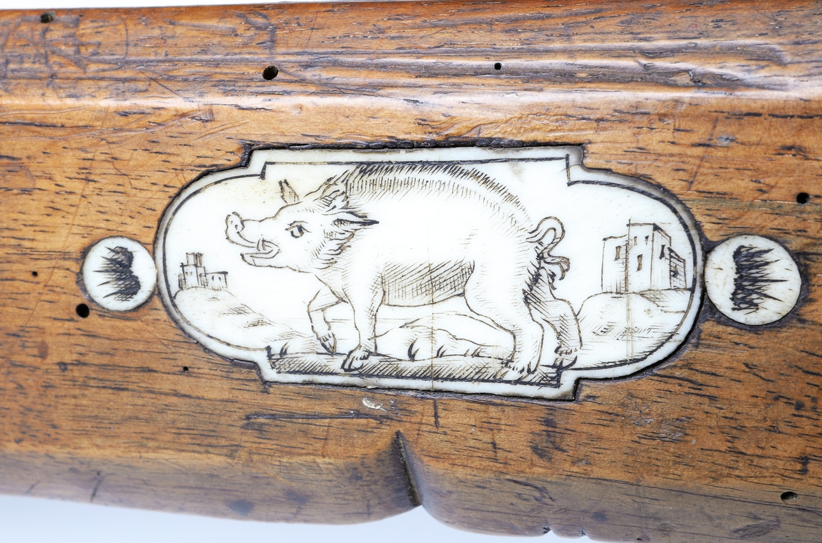 Armborst tillverkat i valnötsträ med båge av stål, försedd med inbygt lås med snälltryck. Stocken har inläggningar av elfenben i medaljonger, vari djur är ingraverade. På kindsidans plattor syns vildsvin, björn, löpande hund och vilande lejon, och på yttersidan löpande hundar, lo och springande hare och lejon. På kolvens översida finns två rankornerade plattor och tumgrepp med skraffering. Bakplåten i elfenben har en inristad krans. Skenan över pilrännan är fastskruvad vid stocken med två järnskruvar. På denna skena finns också sikte och korn av järn. Bågen i stål är i rektangulär genomskärning och hålls fast i kolven med en båglindning. Framför bågen finns en liten bygel i järn, och även varbygeln undertill är i järn. För att spänna bågen så krävs en hävstång eller vindspel för att göra detta. Armborstet har åtta pilar. (Inv. nr. L 3 - L 10), samt spännanordning.
Inskrivet i huvudkatalogen 1794.