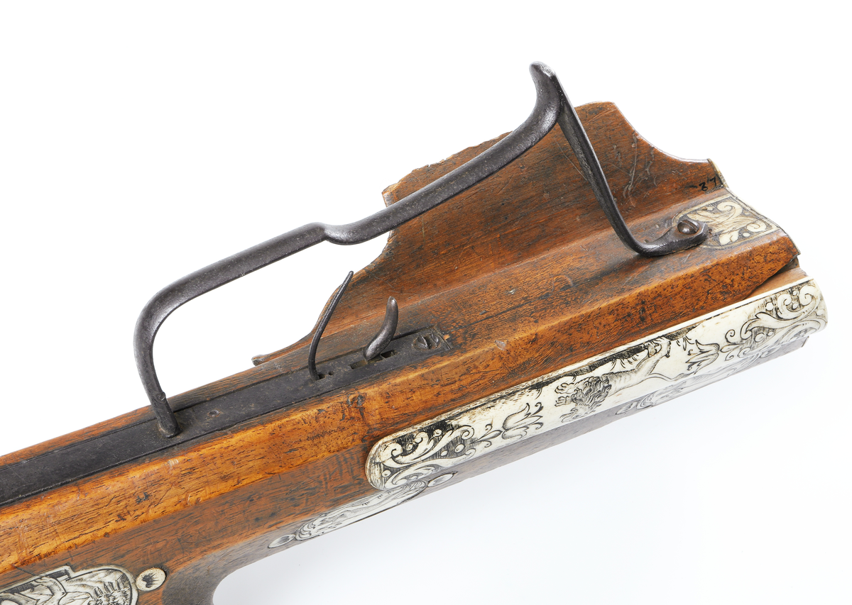 Armborst tillverkat i valnötsträ med båge av stål, försedd med inbygt lås med snälltryck. Stocken har inläggningar av elfenben i medaljonger, vari djur är ingraverade. På kindsidans plattor syns vildsvin, björn, löpande hund och vilande lejon, och på yttersidan löpande hundar, lo och springande hare och lejon. På kolvens översida finns två rankornerade plattor och tumgrepp med skraffering. Bakplåten i elfenben har en inristad krans. Skenan över pilrännan är fastskruvad vid stocken med två järnskruvar. På denna skena finns också sikte och korn av järn. Bågen i stål är i rektangulär genomskärning och hålls fast i kolven med en båglindning. Framför bågen finns en liten bygel i järn, och även varbygeln undertill är i järn. För att spänna bågen så krävs en hävstång eller vindspel för att göra detta. Armborstet har åtta pilar. (Inv. nr. L 3 - L 10), samt spännanordning.
Inskrivet i huvudkatalogen 1794.