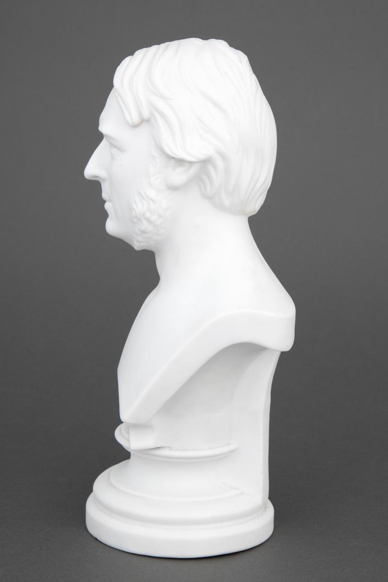 Byste av mann i uglasert porselen. Bysten forestiller Anton Martin Schweigaard, norsk jurist og politiker (1808-1870).