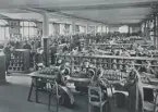 Kvinnor och män i arbete. (Zählerfabrik). (Eichraum). 
Ur album AEG (Die Allgemeine Elektricitäts-Gesellschaft ) 1883-1908.