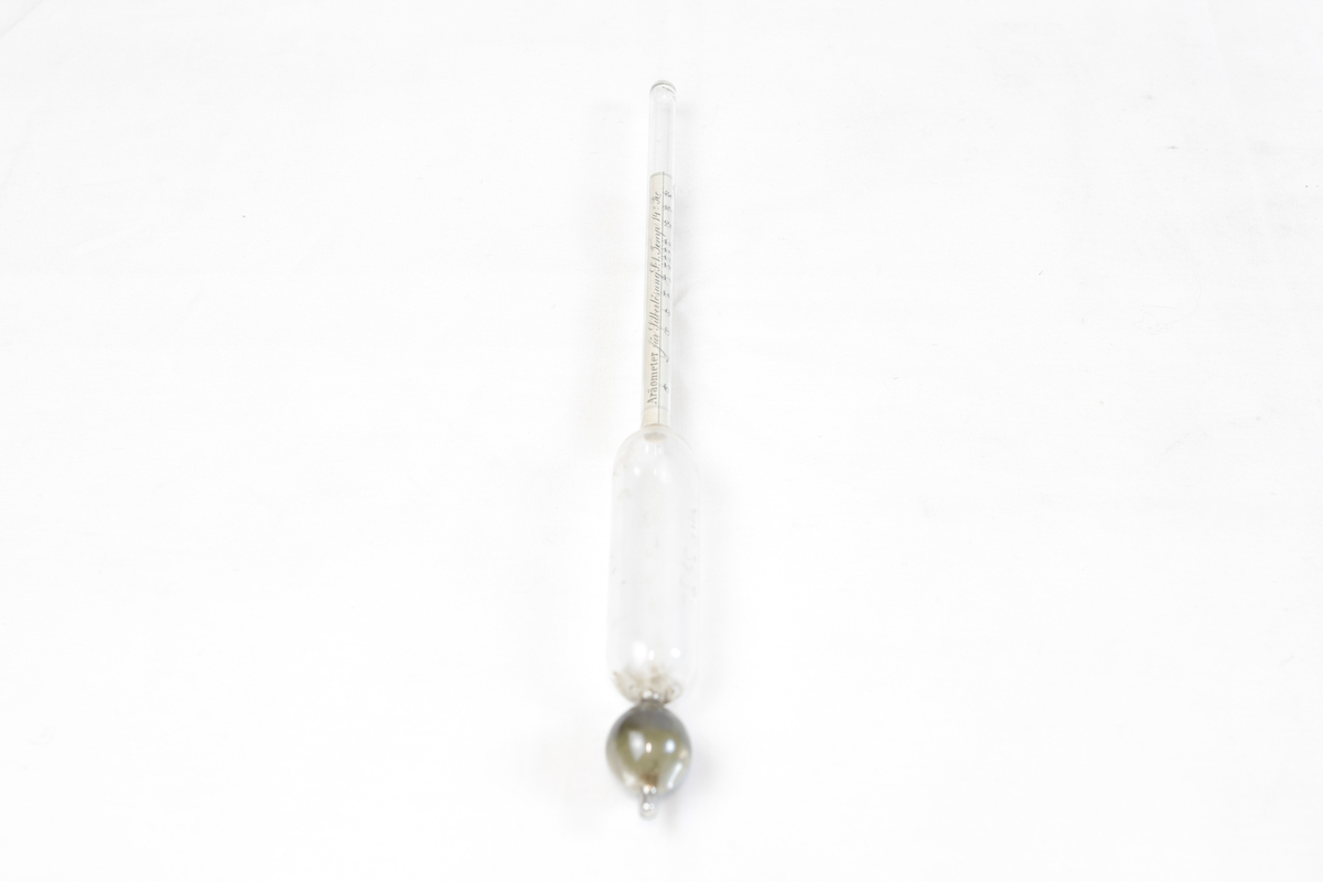 Måleinstrument av glass for måling av sølvinnhold. Glassrøret er formet som et tynn sylinder med en glasskule i den ene enden.