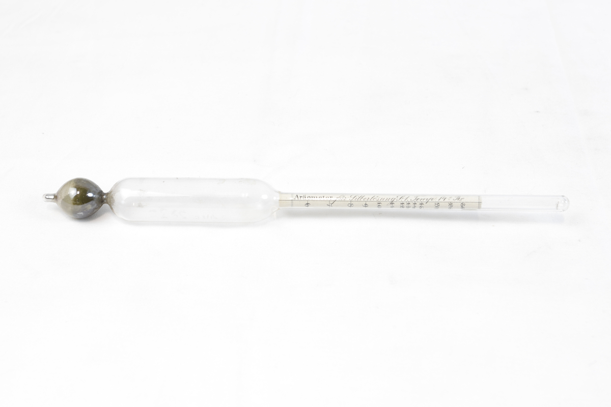 Måleinstrument av glass for måling av sølvinnhold. Glassrøret er formet som et tynn sylinder med en glasskule i den ene enden.