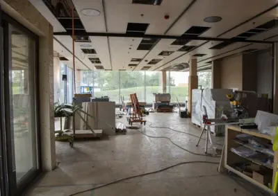 Til venstre for h ovedinngangen i det regionale historiesenteret blir det bibliotek og butikk, her er himlingen under konstruksjon, og golvet er fylt av verktøy og materialstabler.