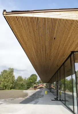 På Mjøssida av historiesenteret er det et bredt takutstikk med langsgående trespiler.