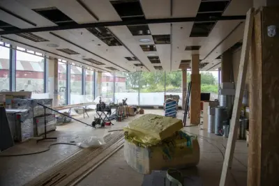 Storhamarlåven skimtes gjennom store vinduer på to vegger, isolasjon og byggematerialer står rundt omkring på golvet, lyse himlingsplater er i ferd med å komme på plass.