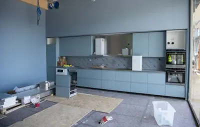 Lyseblå vegger og ronter på et delvis ferdig bygget workshopkjøkken i det regionale historiesenteret.