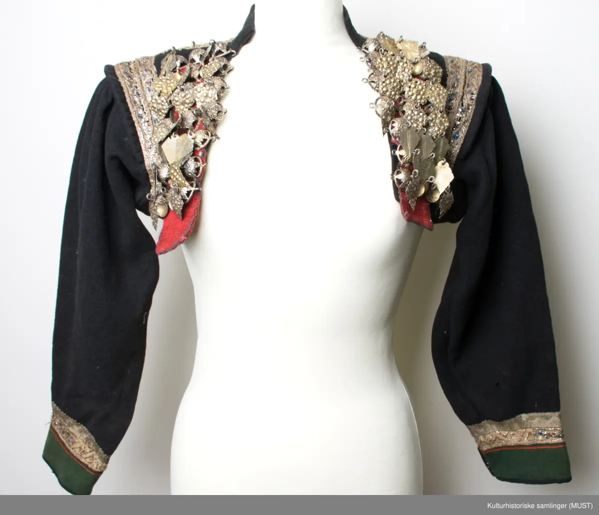 Brudetrøye. Rikt besatt med søljer fremme på rød bunn. Omkring akslene brede sølvbånd. Rundt håndlinningene grønn kant med sølvbånd over.
På ryggen er det sølvbånd i nederste kant samt på skrå fra skulder til nederste kant. Det er to sølvbånd langs armsøm. 
Trøyen har 14 måler med 3 kuler med heng.