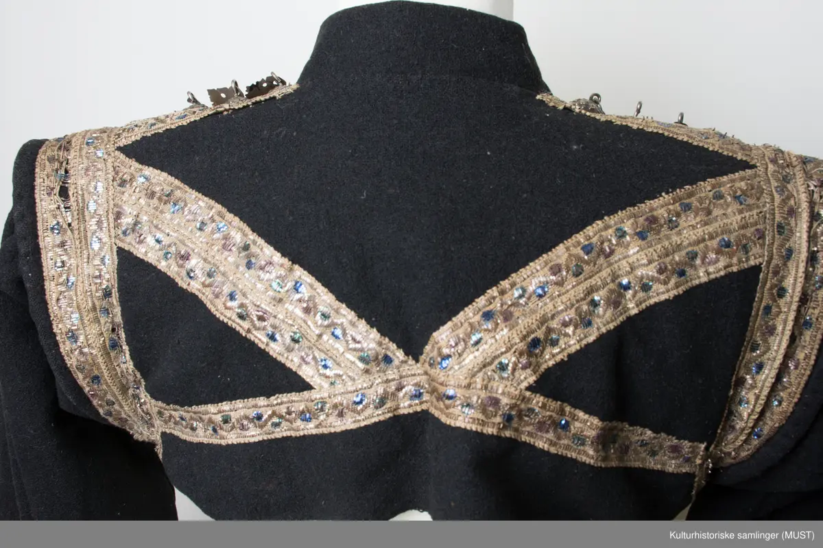 Brudetrøye. Rikt besatt med søljer fremme på rød bunn. Omkring akslene brede sølvbånd. Rundt håndlinningene grønn kant med sølvbånd over.
På ryggen er det sølvbånd i nederste kant samt på skrå fra skulder til nederste kant. Det er to sølvbånd langs armsøm. 
Trøyen har 14 måler med 3 kuler med heng.