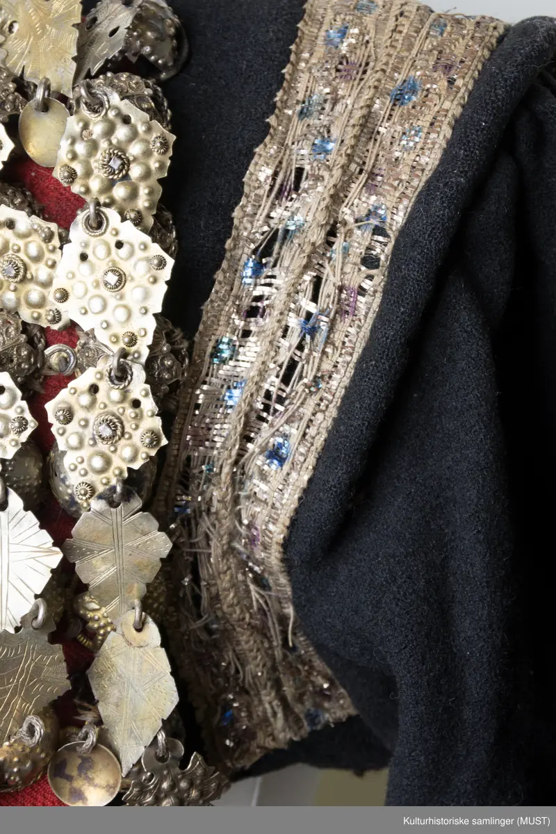 Brudetrøye. Rikt besatt med søljer fremme på rød bunn. Omkring akslene brede sølvbånd. Rundt håndlinningene grønn kant med sølvbånd over.
På ryggen er det sølvbånd i nederste kant samt på skrå fra skulder til nederste kant. Det er to sølvbånd langs armsøm. 
Trøyen har 14 måler med 3 kuler med heng.