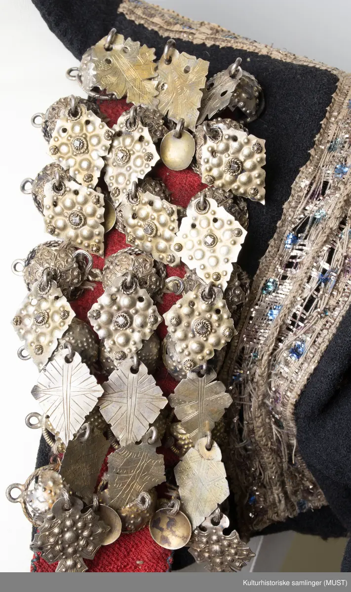 Brudetrøye. Rikt besatt med søljer fremme på rød bunn. Omkring akslene brede sølvbånd. Rundt håndlinningene grønn kant med sølvbånd over.
På ryggen er det sølvbånd i nederste kant samt på skrå fra skulder til nederste kant. Det er to sølvbånd langs armsøm. 
Trøyen har 14 måler med 3 kuler med heng.