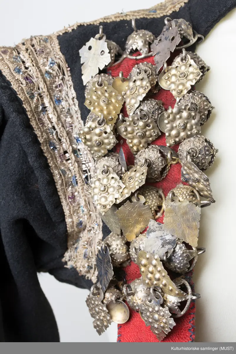 Brudetrøye. Rikt besatt med søljer fremme på rød bunn. Omkring akslene brede sølvbånd. Rundt håndlinningene grønn kant med sølvbånd over.
På ryggen er det sølvbånd i nederste kant samt på skrå fra skulder til nederste kant. Det er to sølvbånd langs armsøm. 
Trøyen har 14 måler med 3 kuler med heng.