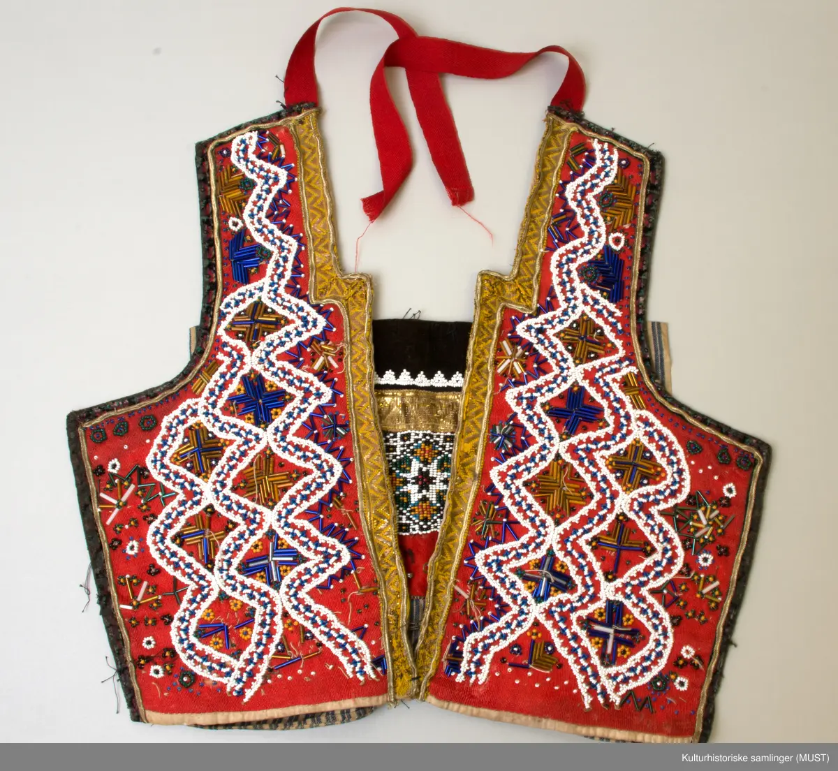 Gull- og sølvbånd og perler, silkebord. Ullbord rundt 3 av sidene