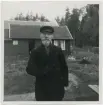 Porträtt på en man framför ett hus.