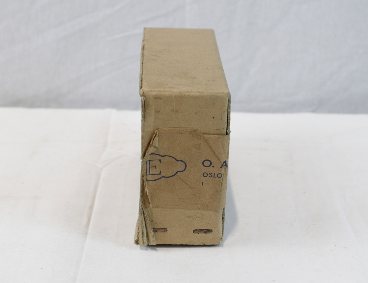 Del av pappeske. Esken har brun papirtape med logo. Brukt til enten oppbevaring eller innpakning av gullsmedgjenstander.