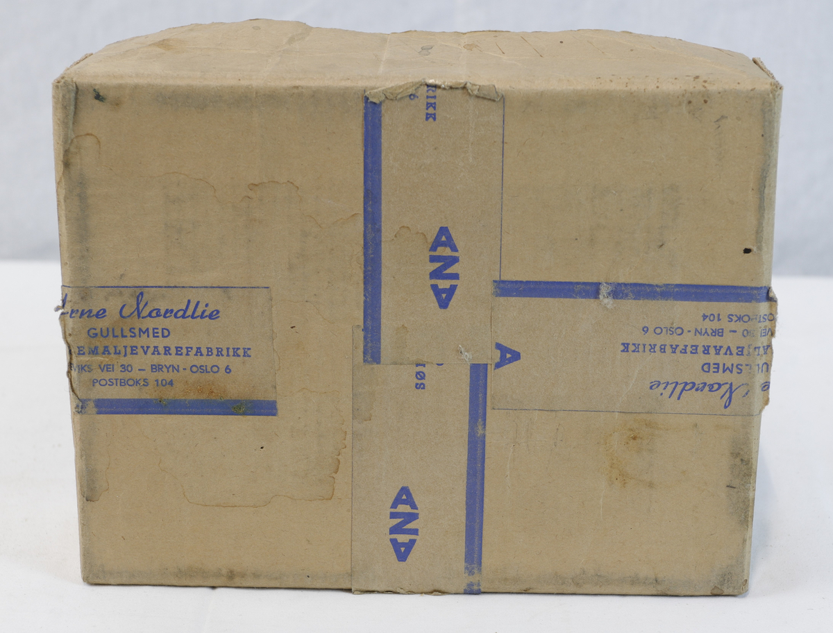 Del av pappeske. Esken har papirtape med logo. Brukt til enten oppbevaring eller innpakning av gullsmedgjenstander.