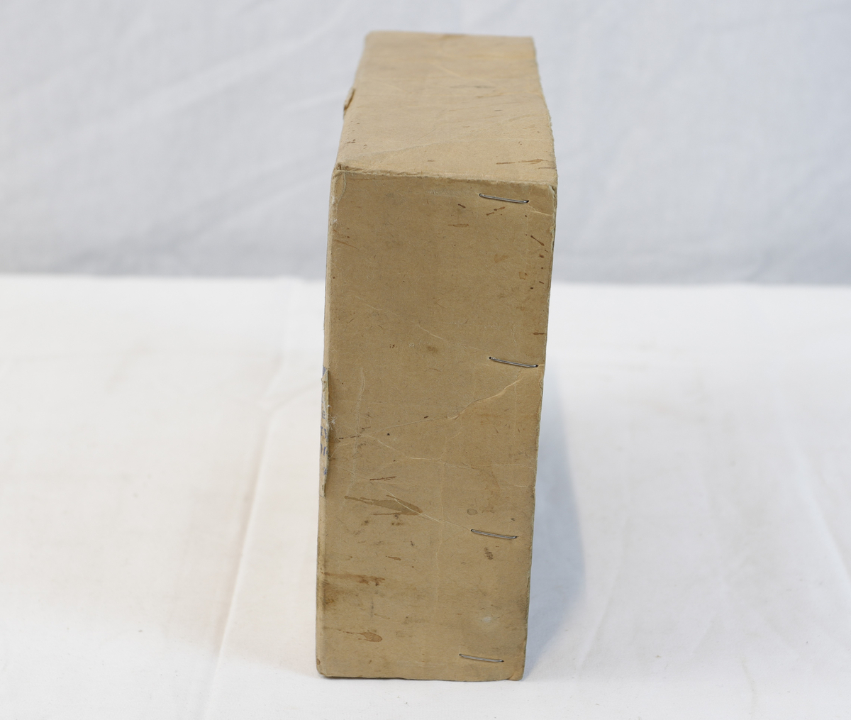 Del av pappeske. Esken har papirtape med logo. Brukt til enten oppbevaring eller innpakning av gullsmedgjenstander.