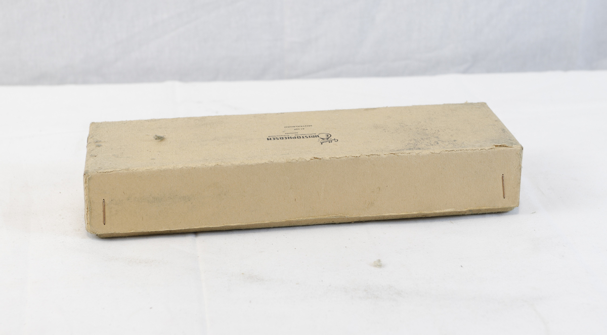 Avlang og kvadratisk pappeske. Pappesken har logo på lokk. Esken er trolig brukt til oppbevaring eller innpakning av gullsmedgjenstander.