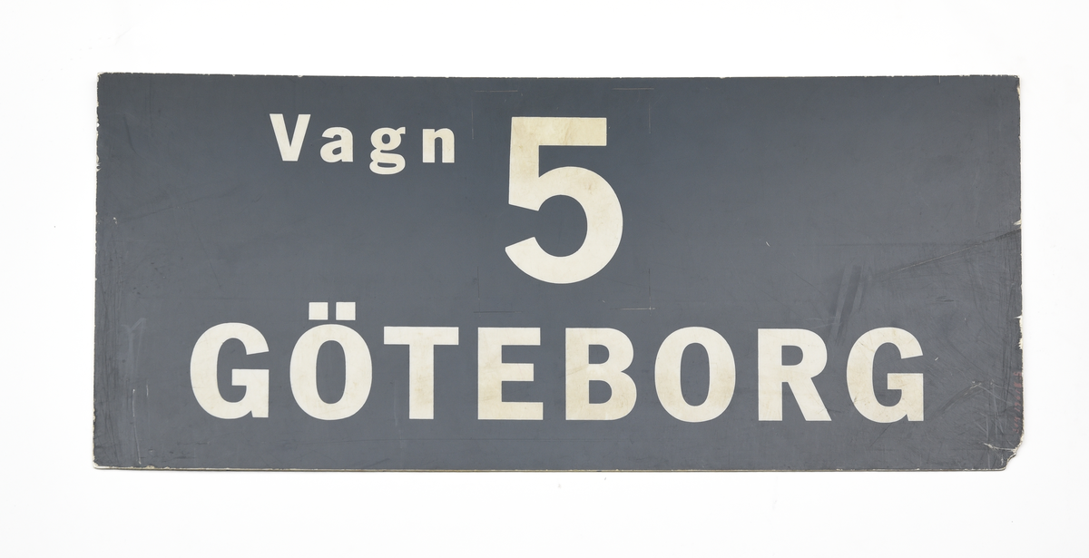 Sex stycken rektangulära dubbelsidiga plastskyltar med vit text på grå botten. 
Text på skyltarna: 
(:1) "Vagn 1, Göteborg".
(:2) "Vagn 2, Göteborg".
(:3) "Vagn 3, Göteborg".
(:4) "Vagn 4, Göteborg".
(:5) "Vagn 5, Göteborg".
(:6) "Vagn 6, Göteborg".

Skyltarna är identiska på båda sidor.