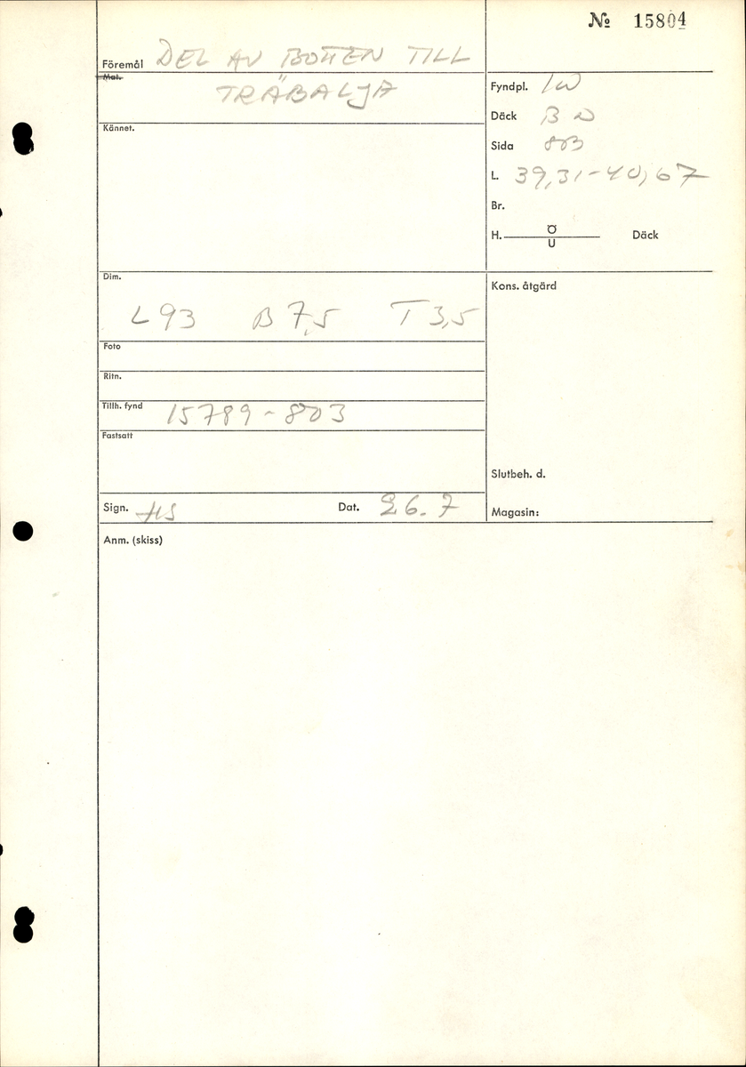 Del av lock till en laggad träbalja. Locket utgörs av tre sammanfogade delar. På lockets ovansida, tvärsöver, löper ett nedsänkt spår där en regel sitter. Föremålet är sprucket på två ställen och består av tre delar. Två av delarna sitter på plats med hjälp av regeln. Den tredje delen är lös och har fått ett nytt fyndnummer.