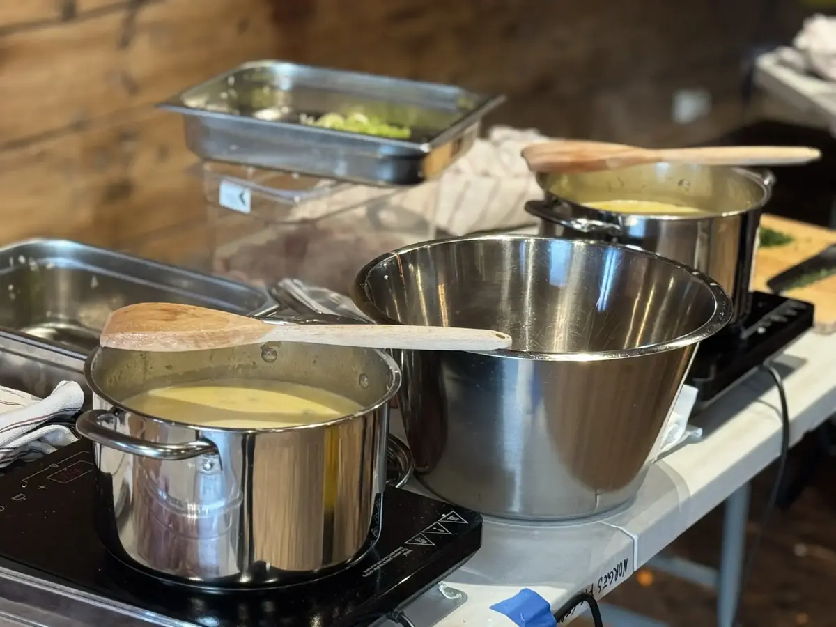 Vi ser to gryter hvor fiskesuppen står og putrer