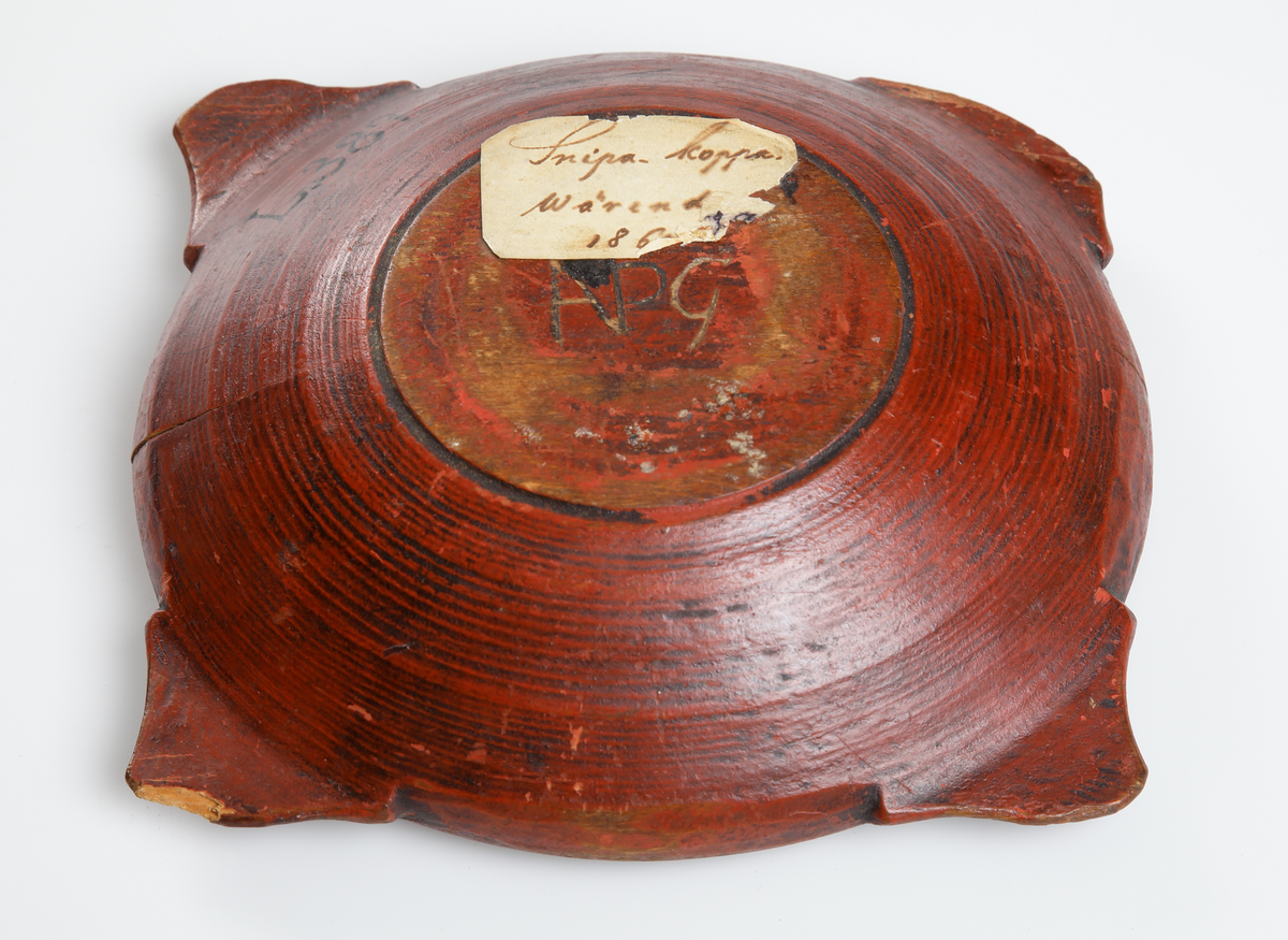 Snipaskål av trä. Rund skål med fyra platta handtag, jämt placerade runt mynningen. Med inskrift och målad dekor. 
Inskrivet i huvudbok 1867.