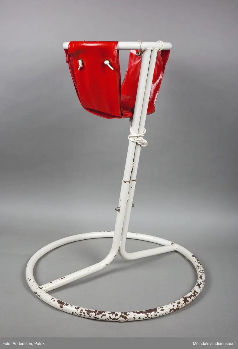 Barnstol tillverkad av ett vitt stålstativ med en rund bas och en mindre rund ram. Själva sittdynan består av en ”påse” i vinyl som är förankrad i den mindre ringen på stativet.

Sitsen var från början grön, givaren har bytt till en röd.