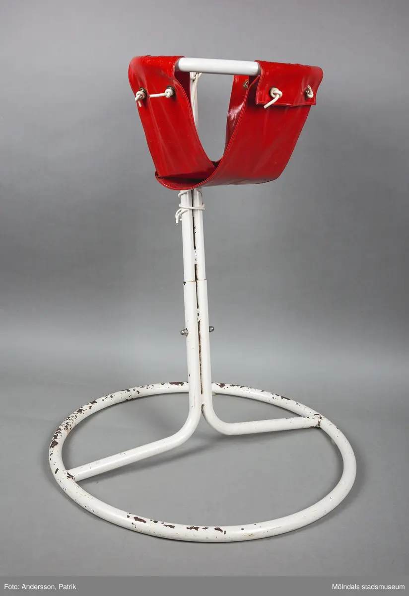 Barnstol tillverkad av ett vitt stålstativ med en rund bas och en mindre rund ram. Själva sittdynan består av en ”påse” i vinyl som är förankrad i den mindre ringen på stativet.

Sitsen var från början grön, givaren har bytt till en röd.