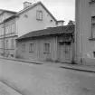 Det låga gatuhuset till gården Hunnebergsgatan 24 i Linköping har fått stå kvar och döljer en väl bebyggd gårdsinteriör. Här en dokumentation daterad 1961.