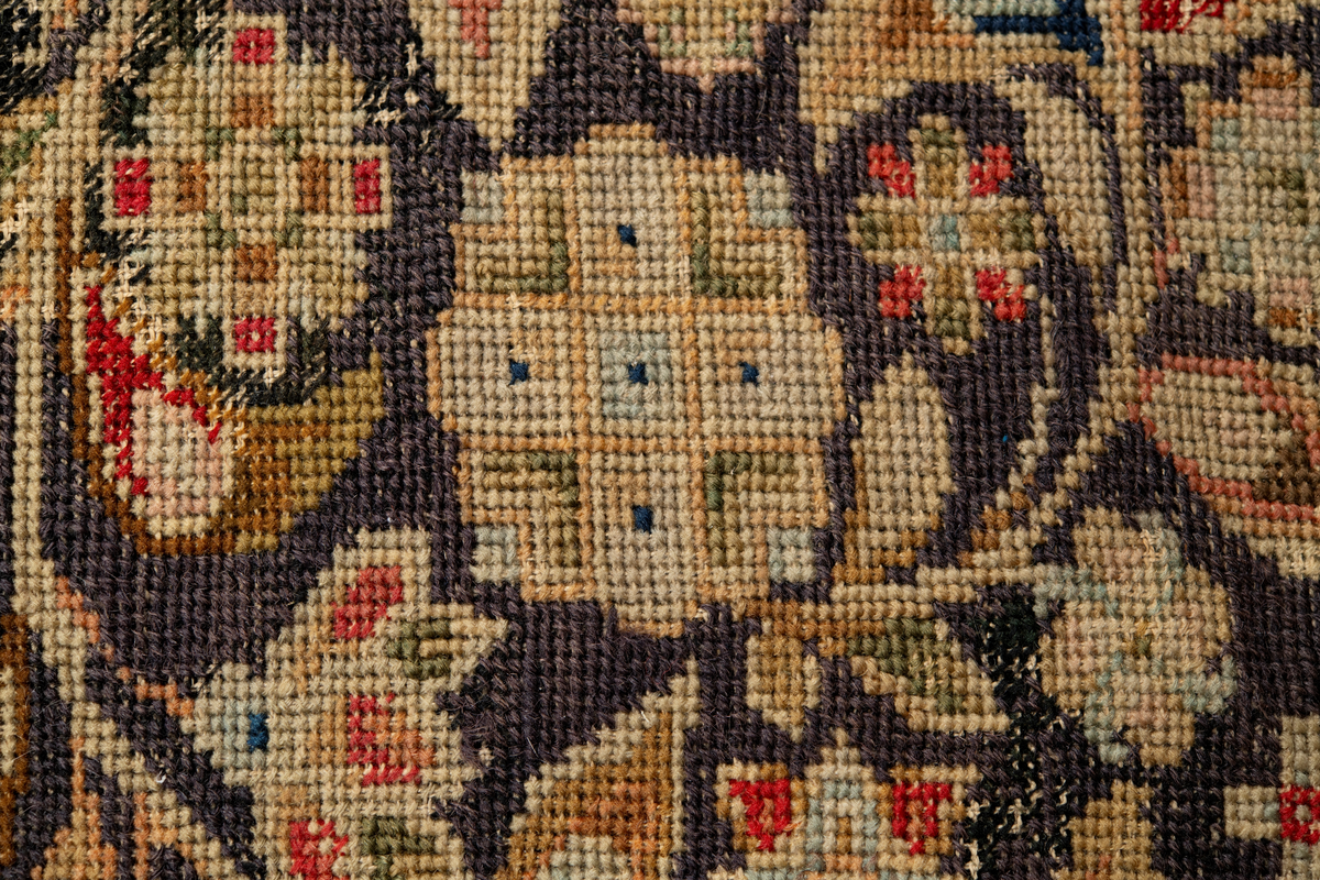 Linbotten med broderier i framför allt ull. Vissa detaljer troligen gjorda i silke. Lagningarna utförda i ull och bomull. Broderiet gjort i korsstygn. De äldsta delarna (bården) är gjorda i olika stora stygn varför ytans karaktär varierar. Mönster som påminner om pompeijansk stil med bland annat kartusher, urnor och växtornament. Mittpartiet inramat med roccaier eller akantusblad, blombotten med liljor och rosor samt vinrankor. Längst ena långsidan även inslag av korall. Hörn med spiralformade blomstergirlanger, dessa med drag av folkligt broderi.
Brunsvart botten, ojämt blekt. Merparten beigegröna nyanser på växtornamenten. Blåa och röda inslag där vissa röda delar skulle kunna vara anilinfärg, troligen i övrigt växtfärg.