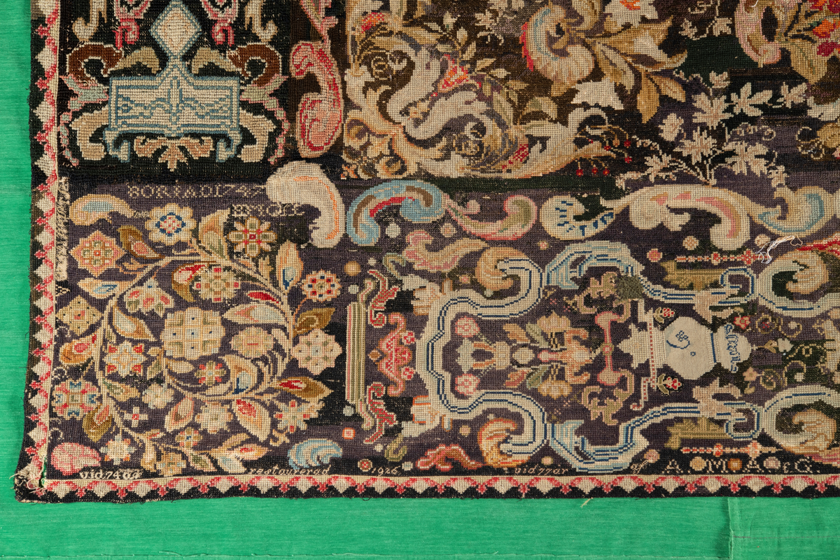 Linbotten med broderier i framför allt ull. Vissa detaljer troligen gjorda i silke. Lagningarna utförda i ull och bomull. Broderiet gjort i korsstygn. De äldsta delarna (bården) är gjorda i olika stora stygn varför ytans karaktär varierar. Mönster som påminner om pompeijansk stil med bland annat kartusher, urnor och växtornament. Mittpartiet inramat med roccaier eller akantusblad, blombotten med liljor och rosor samt vinrankor. Längst ena långsidan även inslag av korall. Hörn med spiralformade blomstergirlanger, dessa med drag av folkligt broderi.
Brunsvart botten, ojämt blekt. Merparten beigegröna nyanser på växtornamenten. Blåa och röda inslag där vissa röda delar skulle kunna vara anilinfärg, troligen i övrigt växtfärg.