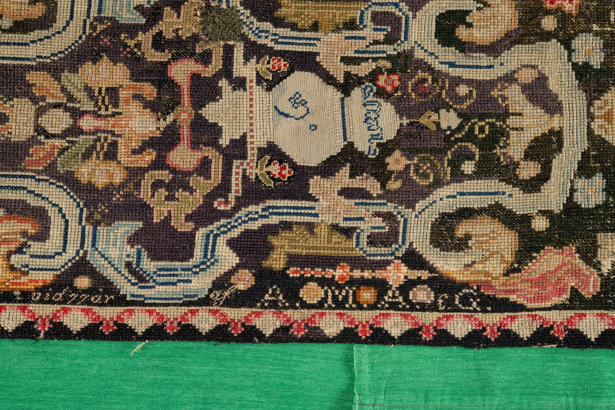 Linbotten med broderier i framför allt ull. Vissa detaljer troligen gjorda i silke. Lagningarna utförda i ull och bomull. Broderiet gjort i korsstygn. De äldsta delarna (bården) är gjorda i olika stora stygn varför ytans karaktär varierar. Mönster som påminner om pompeijansk stil med bland annat kartusher, urnor och växtornament. Mittpartiet inramat med roccaier eller akantusblad, blombotten med liljor och rosor samt vinrankor. Längst ena långsidan även inslag av korall. Hörn med spiralformade blomstergirlanger, dessa med drag av folkligt broderi.
Brunsvart botten, ojämt blekt. Merparten beigegröna nyanser på växtornamenten. Blåa och röda inslag där vissa röda delar skulle kunna vara anilinfärg, troligen i övrigt växtfärg.