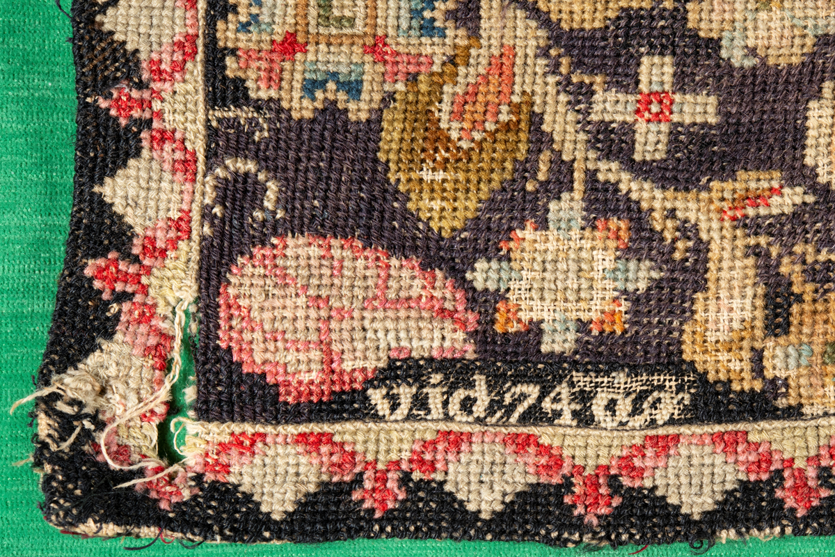 Linbotten med broderier i framför allt ull. Vissa detaljer troligen gjorda i silke. Lagningarna utförda i ull och bomull. Broderiet gjort i korsstygn. De äldsta delarna (bården) är gjorda i olika stora stygn varför ytans karaktär varierar. Mönster som påminner om pompeijansk stil med bland annat kartusher, urnor och växtornament. Mittpartiet inramat med roccaier eller akantusblad, blombotten med liljor och rosor samt vinrankor. Längst ena långsidan även inslag av korall. Hörn med spiralformade blomstergirlanger, dessa med drag av folkligt broderi.
Brunsvart botten, ojämt blekt. Merparten beigegröna nyanser på växtornamenten. Blåa och röda inslag där vissa röda delar skulle kunna vara anilinfärg, troligen i övrigt växtfärg.