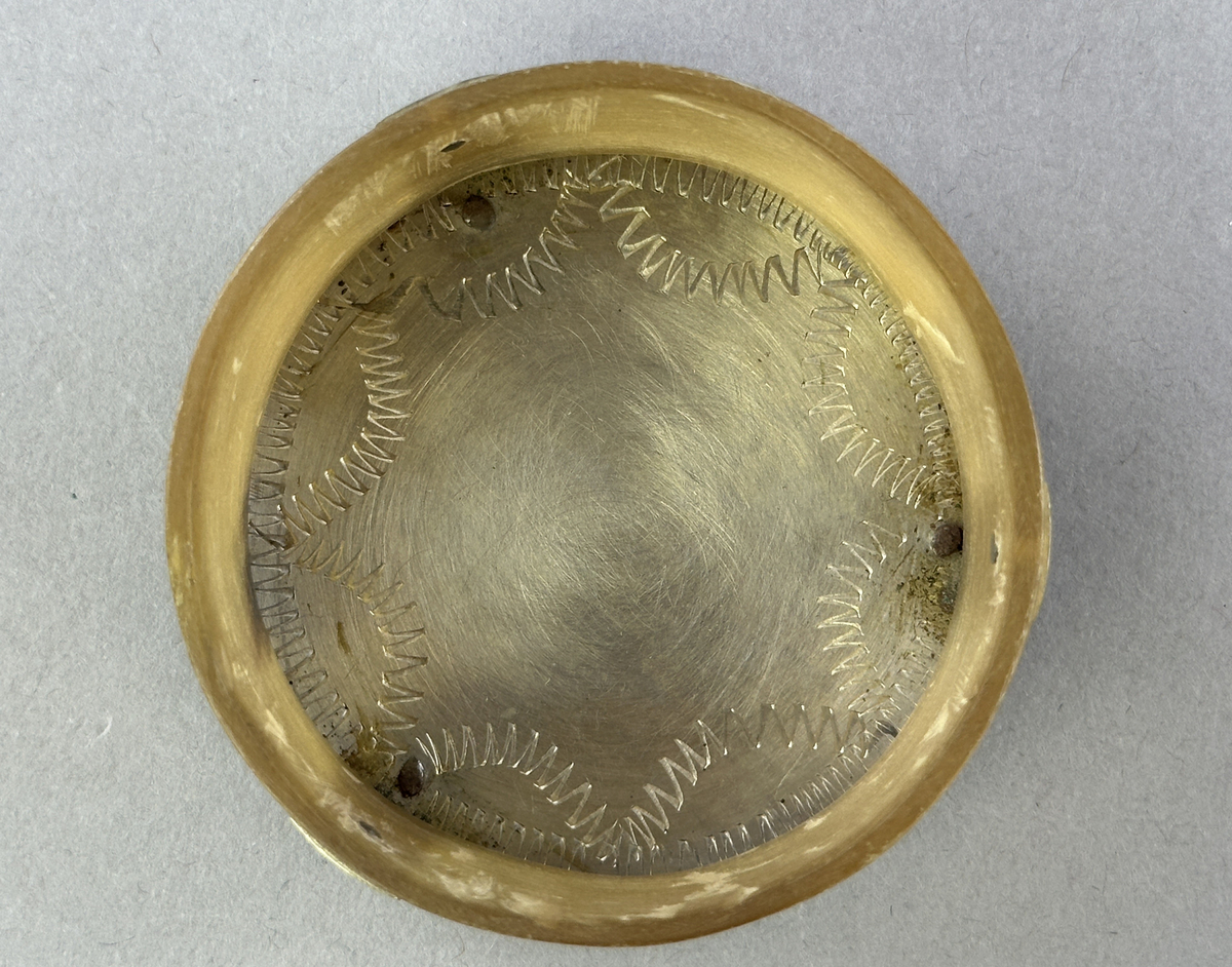 Saltkar, i form av rund burk med lock, i silversmide utfört av resandefolk. Metall i botten och lock med graverat mönster. Kohorn mellan botten och lock, ben i fötter och knopp. Till saltkaret hör en sked, se inv.nr 0875.