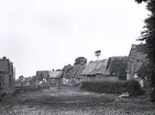 Foto av en by med hus av halmtak vid Normandie, 1921.