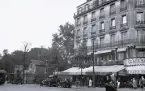 Foto av en byggnad som inrymmer restaurang, café mm. som ger en känsla av stadsliv och aktivitet, troligen Paris, 1924-25.