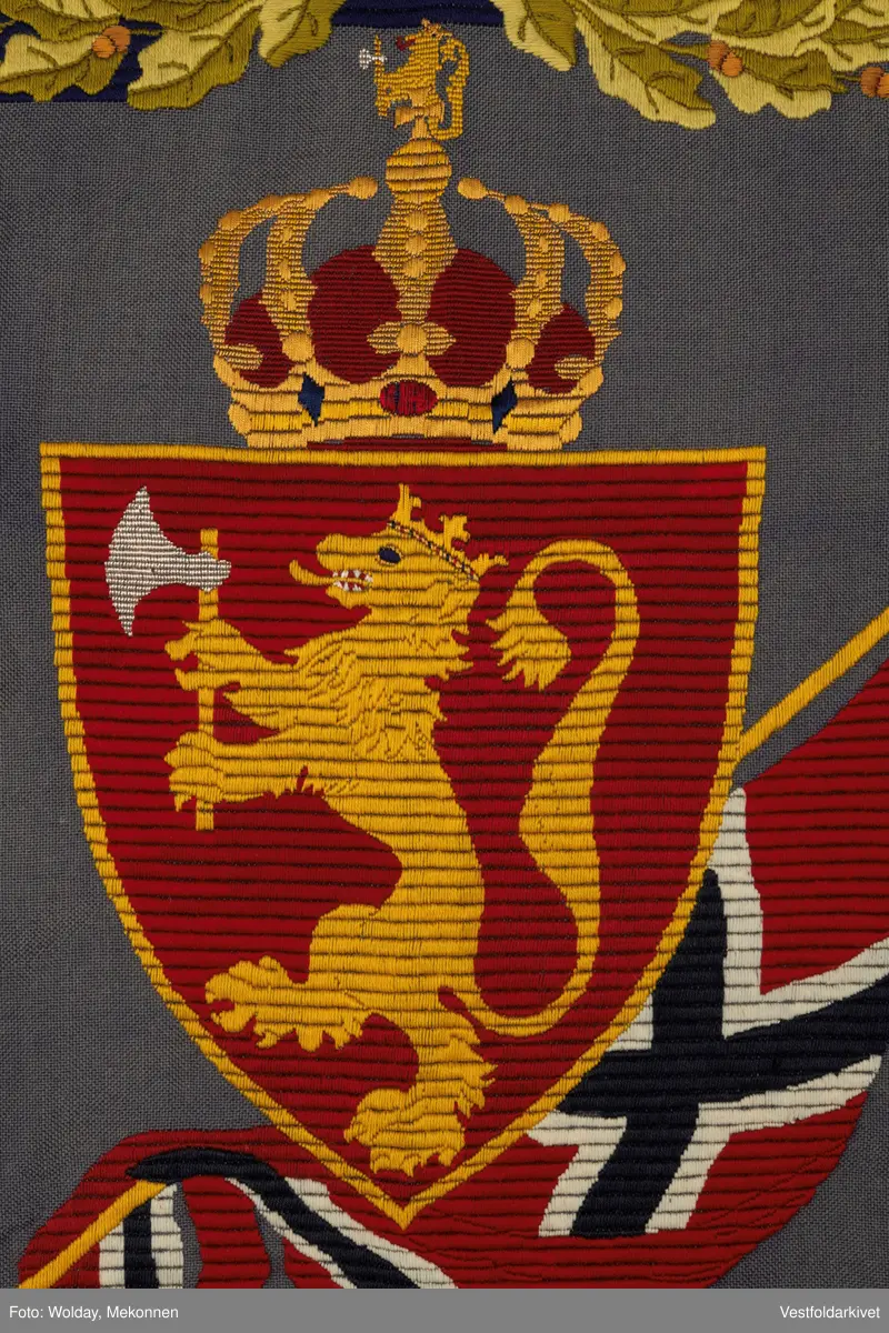 Blått veggteppe med riksvåpenet, påfestet rosetter 