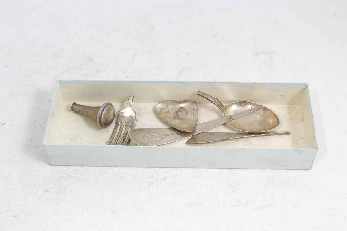 Rektangulær pappeske som inneholder sølvbestikk.