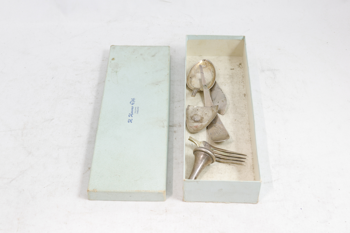 Rektangulær pappeske som inneholder sølvbestikk.