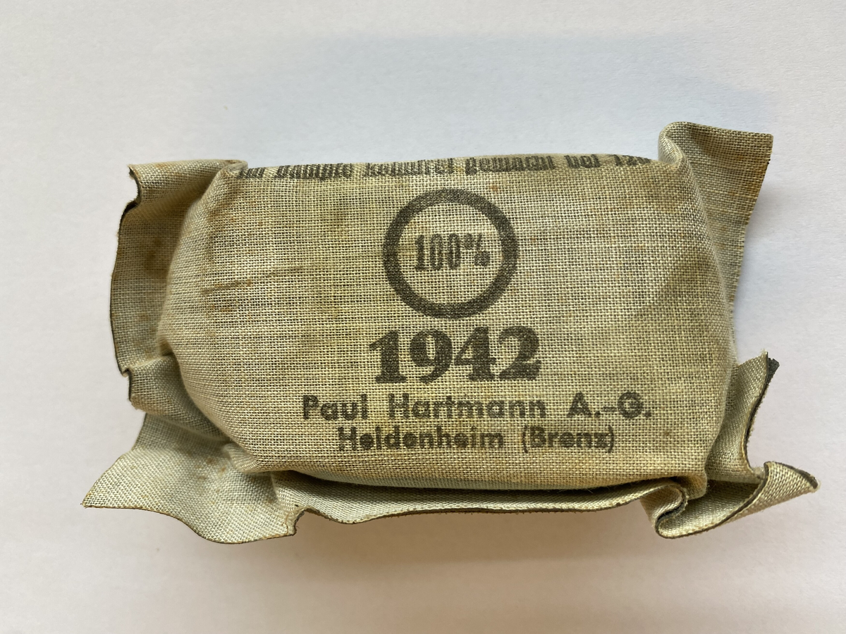 Ein bandasjeforpakning med informasjon trykt på tekstilen. Innpakka i stoff.