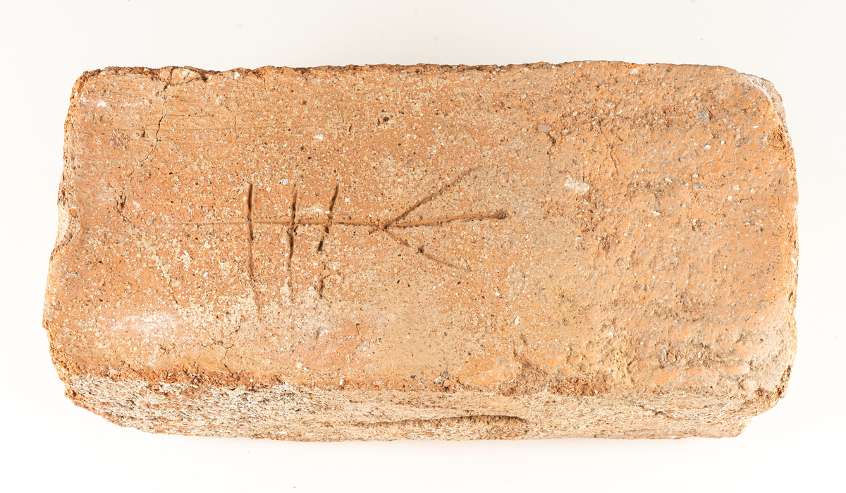 Medeltida tegelsten med bomärke.