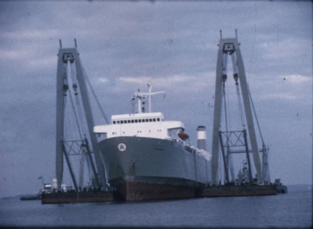 Från bärgningen av tyska lastfartyget M/S STARMARK, som gick på grund i Söderarmsleden i Stockholms norra skärgård den 3 september 1971. Fartyget var så hårt grundsatt att det inte kunde dras flott på vanligt sätt. Med hjälp av Neptunbolagets pontonkranar MAGNUS I och MAGNUS II lyftes fartyget från grunden och bogserades bort från platsen för att repareras på varv.


Filmen dokumenterar huvudsakligen Neptunbolagets arbete med att ansluta pontonkranarna till STARMARK inför lyftet av lastfartyget.