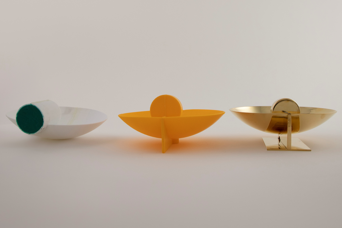 Vegglampe i messing. Rund parabolformet skive med telysholder foran. Rektangulært feste på baksiden med en avstandsplate mellom feste og parabol. Designet tar opp i seg den pre-elektriske lampetypen med reflektorskjerm. 

To 3D-printede prototyper i plast. En hvit prototyp for en bordversjon av lampen, som har en rund parabol festet til en høy sylinder. Sylinderen fungerer som både fot og telysholder. Grønt kitt under basen.
 
Gul prototyp for vegglampen. Samme utforming som messinglampen, men har ikke rektangulært feste med avstandsplate på samme måten. Avstandsplaten på prototypen er festet på nedre halvdel av parabolen, og veggfestet er festet direkte på parabolen.