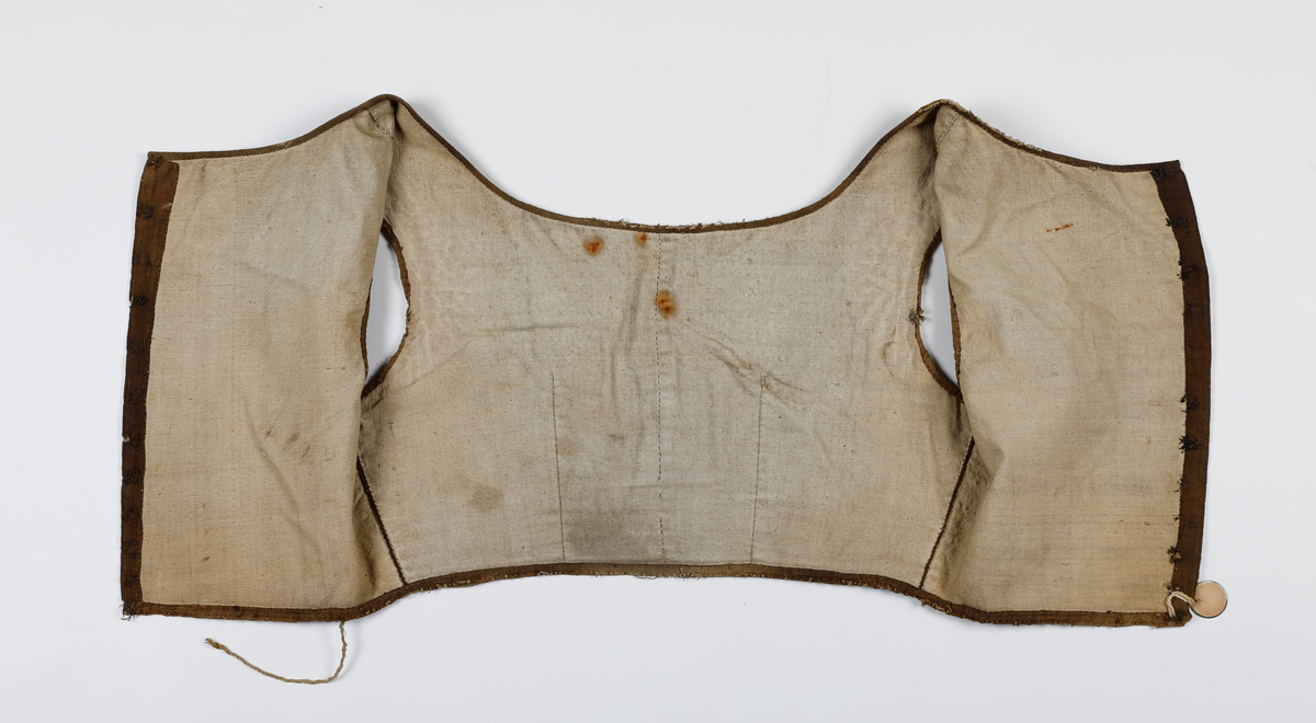 Kjoleliv som er fôret og hektes sammen i ryggen. Fôret er av lin og ellers er livet av bomull. Det er lagt inn snor i folden i nedkant og i front (passe poilerte kanter). Skjørtet har vært festet i livet, men er sprettet av. Livet har hatt 11 hekter, som nå er fjernet, og trådrester sitter igjen etter disse. 