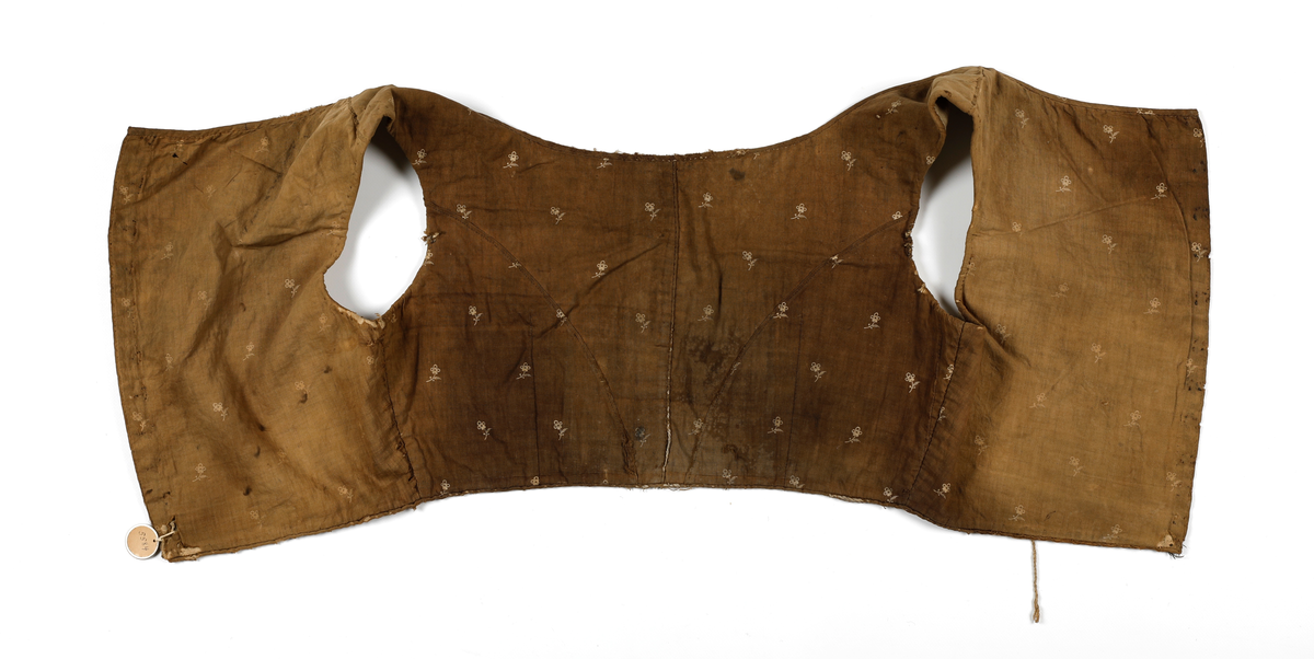 Kjoleliv som er fôret og hektes sammen i ryggen. Fôret er av lin og ellers er livet av bomull. Det er lagt inn snor i folden i nedkant og i front (passe poilerte kanter). Skjørtet har vært festet i livet, men er sprettet av. Livet har hatt 11 hekter, som nå er fjernet, og trådrester sitter igjen etter disse. 