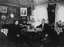 Ektepar fotografert i stua si. Fam. Kolberg, Gressvik. Flytt